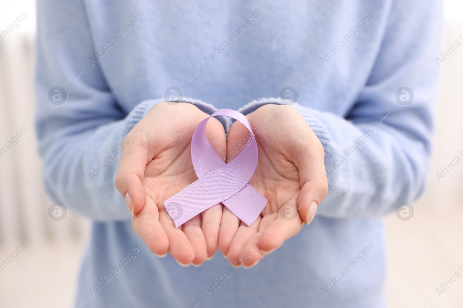 Photo of Woman with violet ribbon on light background, closeup. Alzheimer disease, epilepsy and pancreas cancer awareness