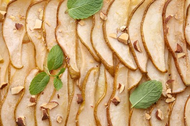 Photo of Delicious puff pastry tart with pears, almond and mint as background, top view