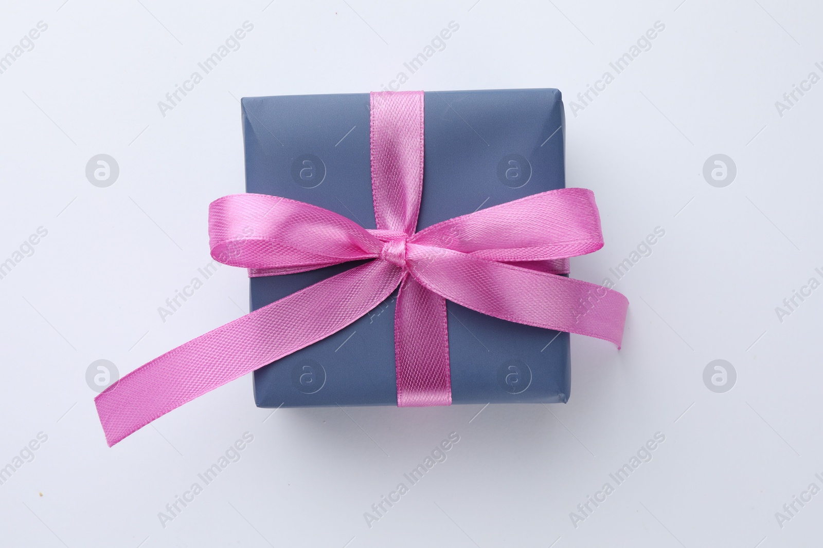 Photo of Beautiful gift box with pink bow isolated on white, top view