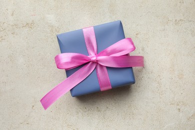 Photo of Beautiful gift box with pink bow on light grey table, top view