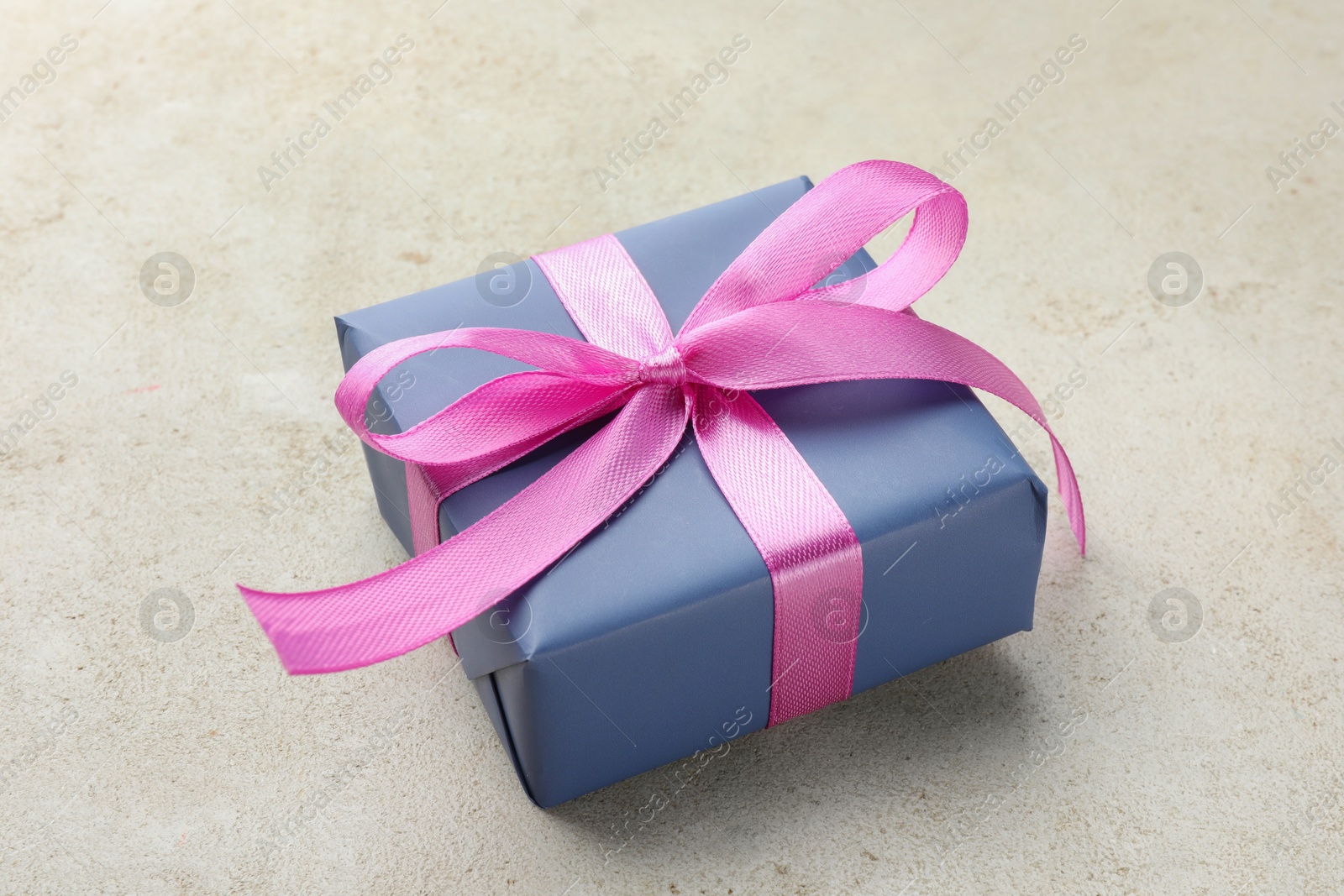 Photo of Beautiful gift box with pink bow on light grey table