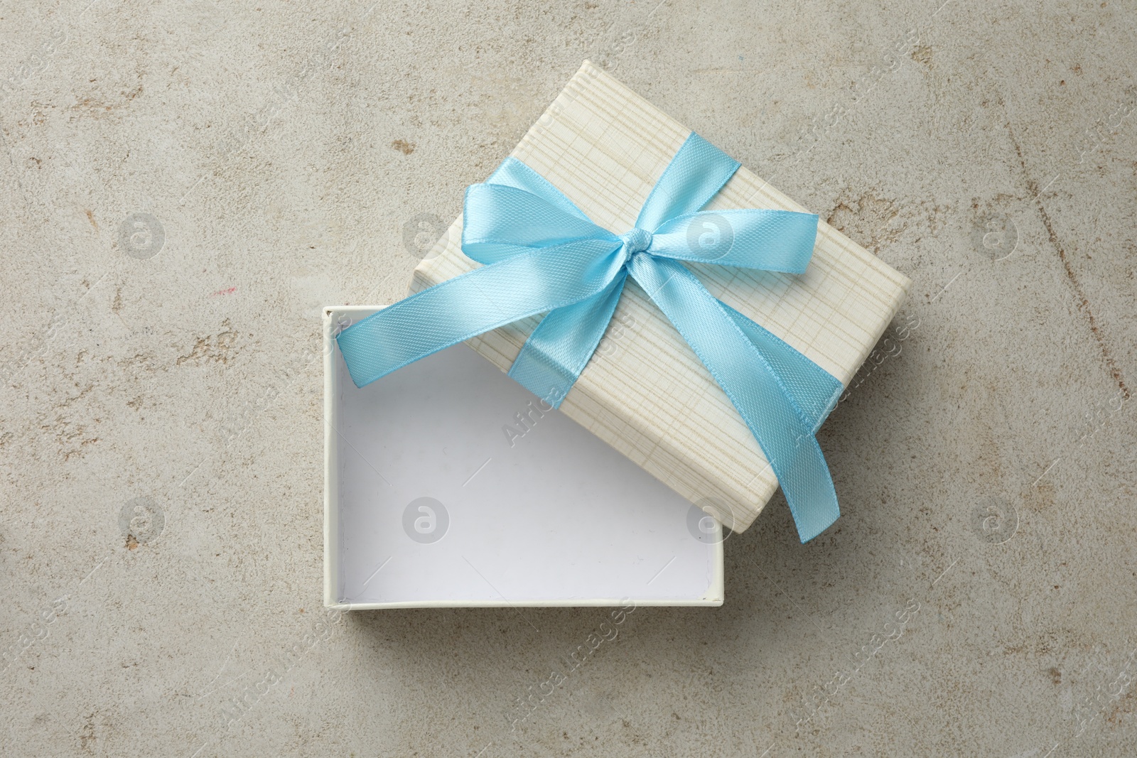 Photo of Empty gift box with bow on light grey table, top view