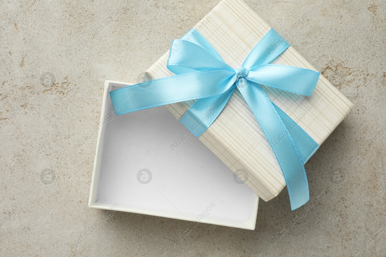 Photo of Empty gift box with bow on light grey table, top view