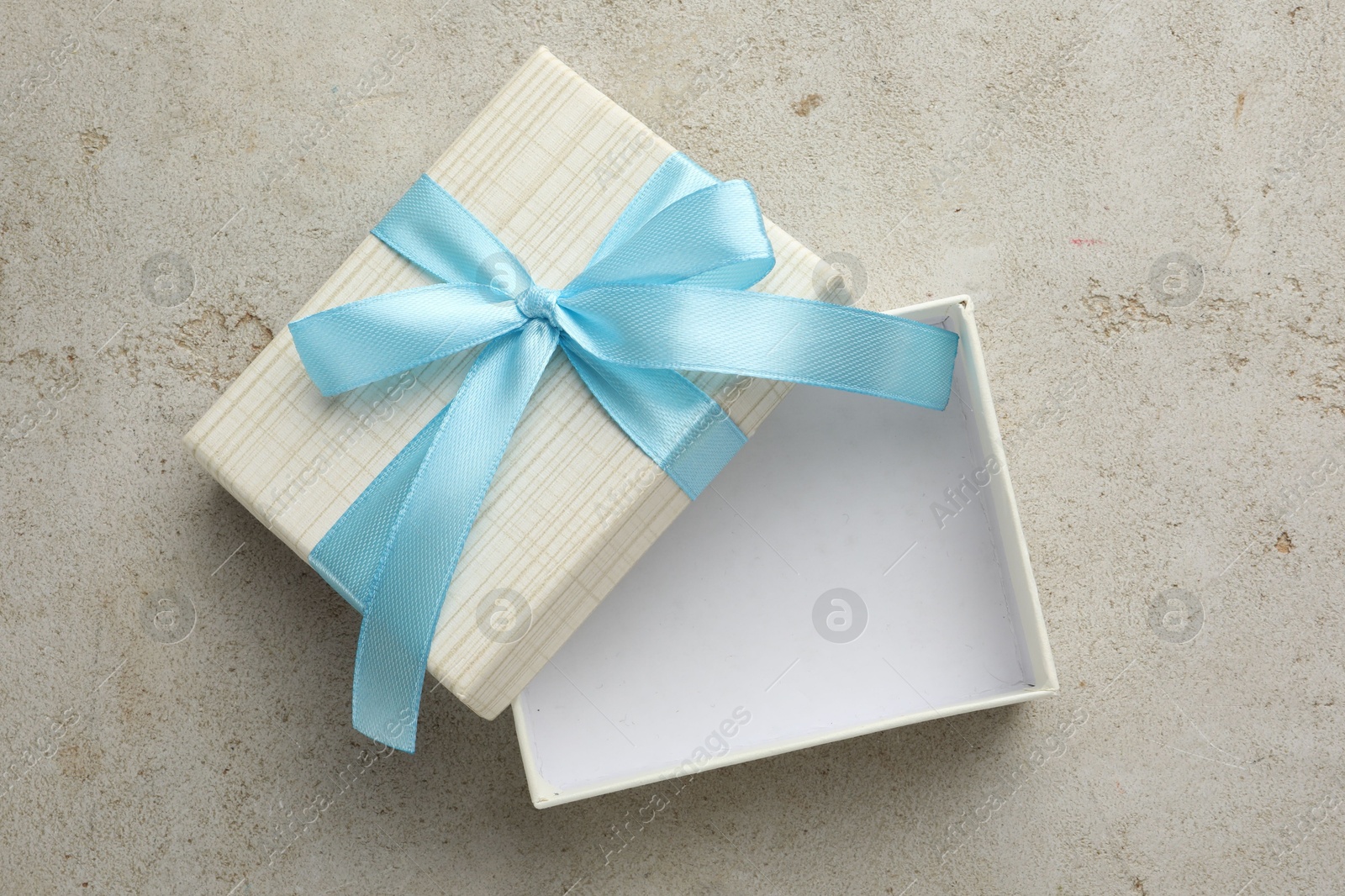 Photo of Empty gift box with bow on light grey table, top view