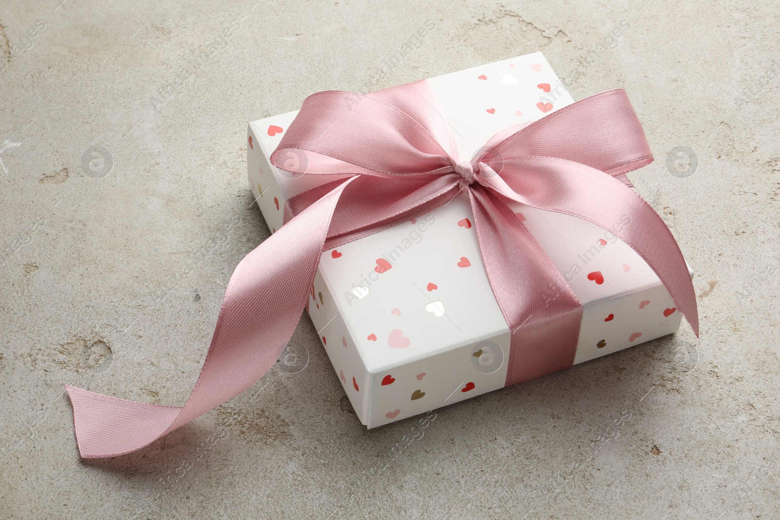 Photo of Beautiful gift box with pink ribbon on light grey table