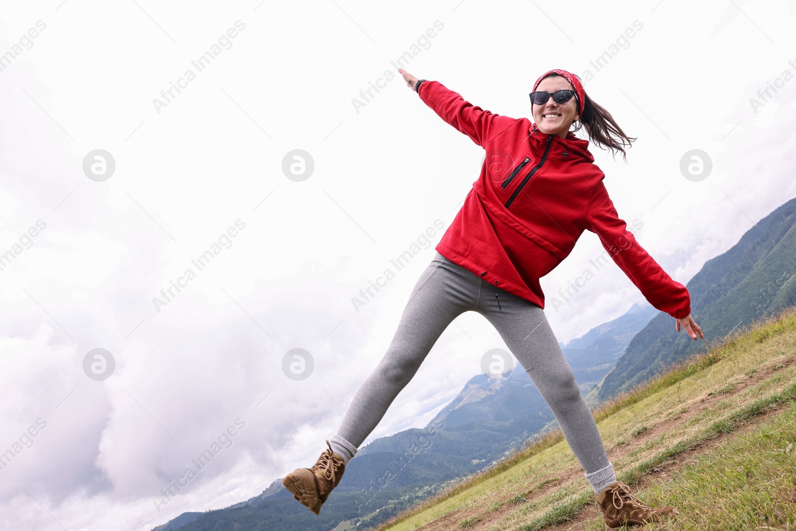 Photo of Happy young hiker in mountains, low angle view