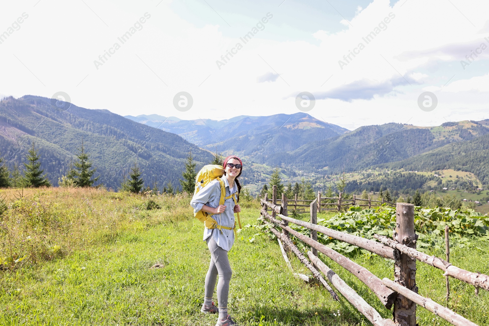 Photo of Happy young hiker with backpack in mountains