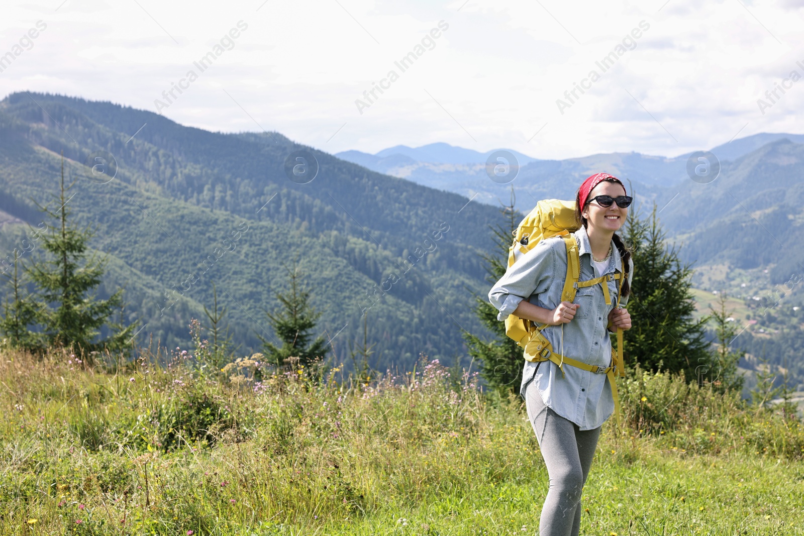 Photo of Happy young hiker with backpack in mountains