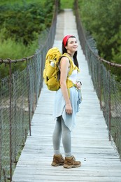 Photo of Young hiker on wooden bridge over river