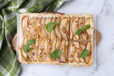 Tasty puff pastry pie with pears and mint on white marble table, top view