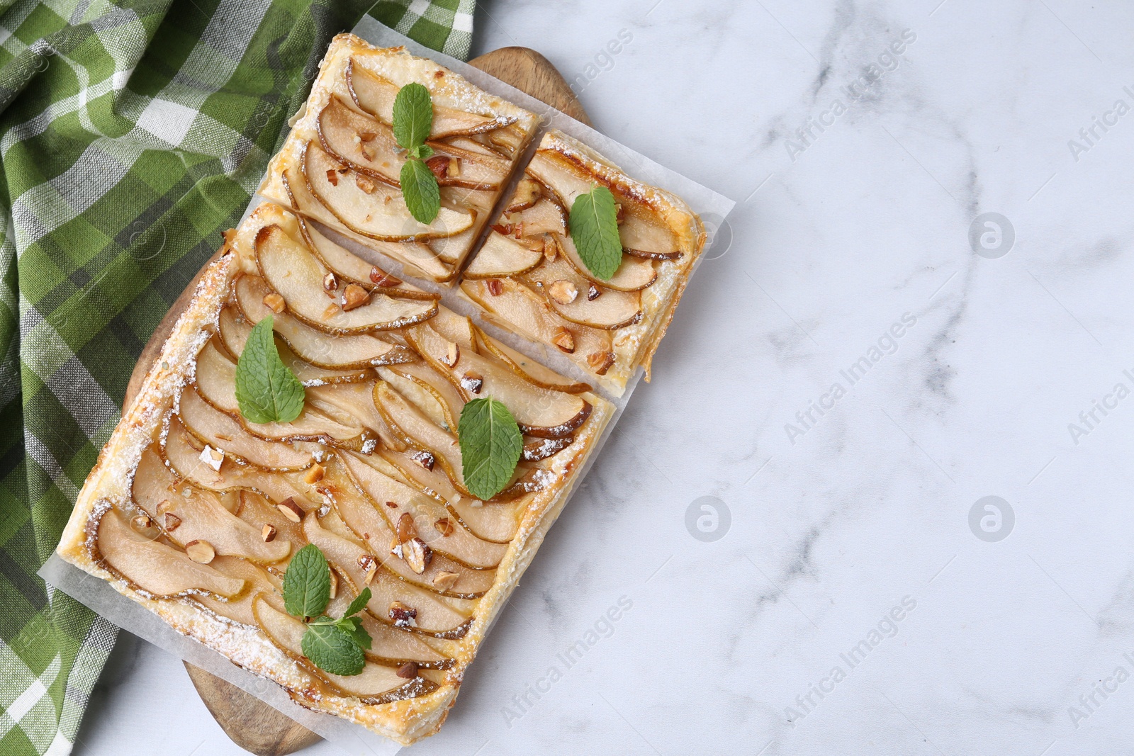 Photo of Tasty puff pastry pie with pears and mint on white marble table, top view. Space for text