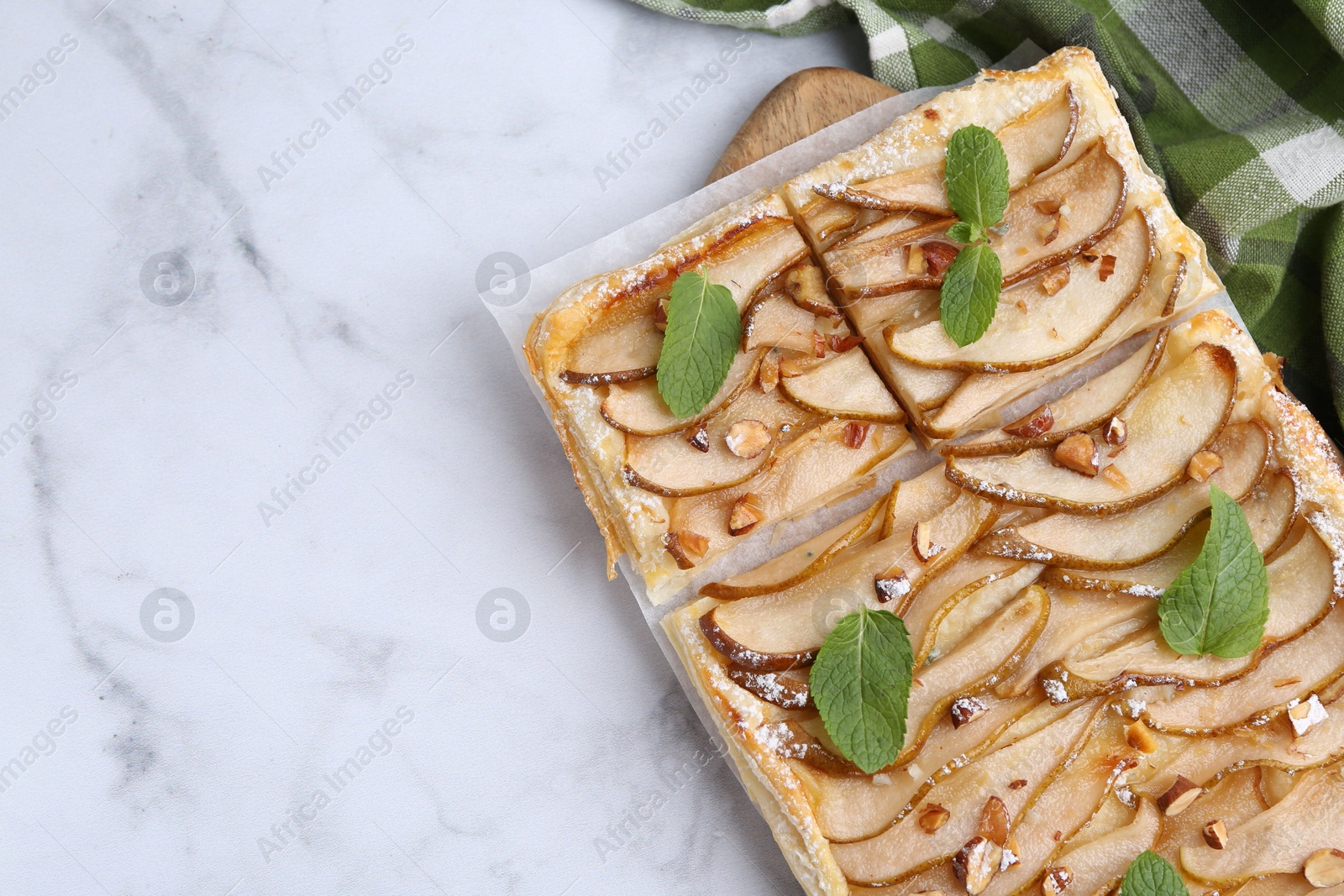 Photo of Tasty puff pastry pie with pears and mint on white marble table, top view. Space for text