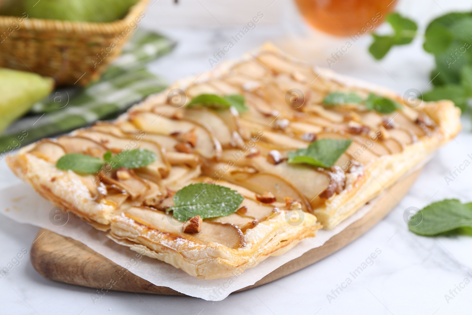 Photo of Tasty puff pastry pie with pears and mint on white table, closeup