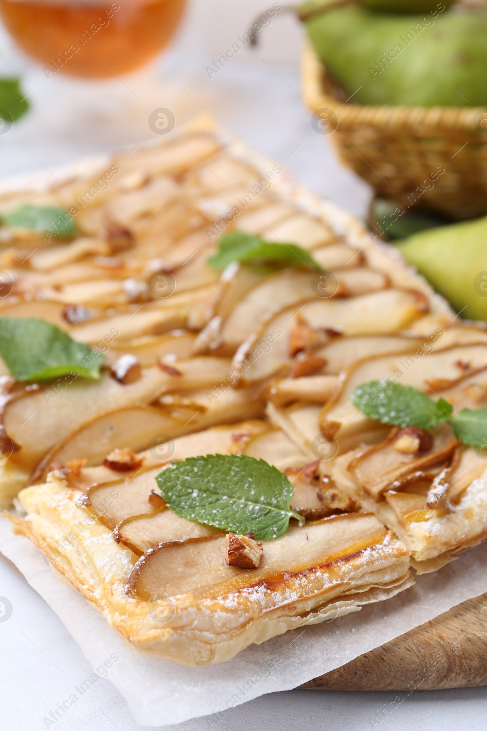 Photo of Tasty puff pastry pie with pears and mint on table, closeup