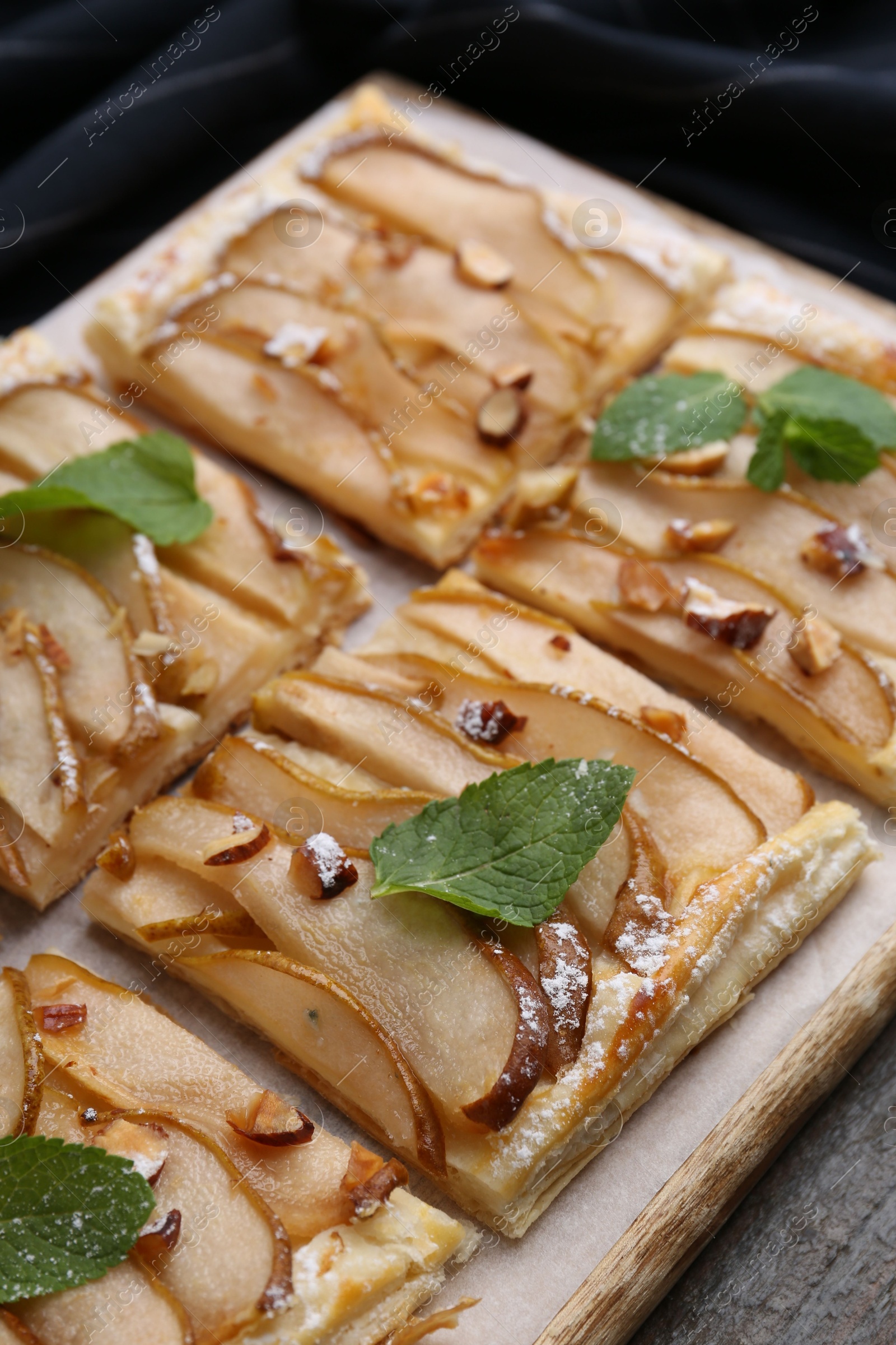 Photo of Tasty puff pastry pie with pears and mint on table, closeup