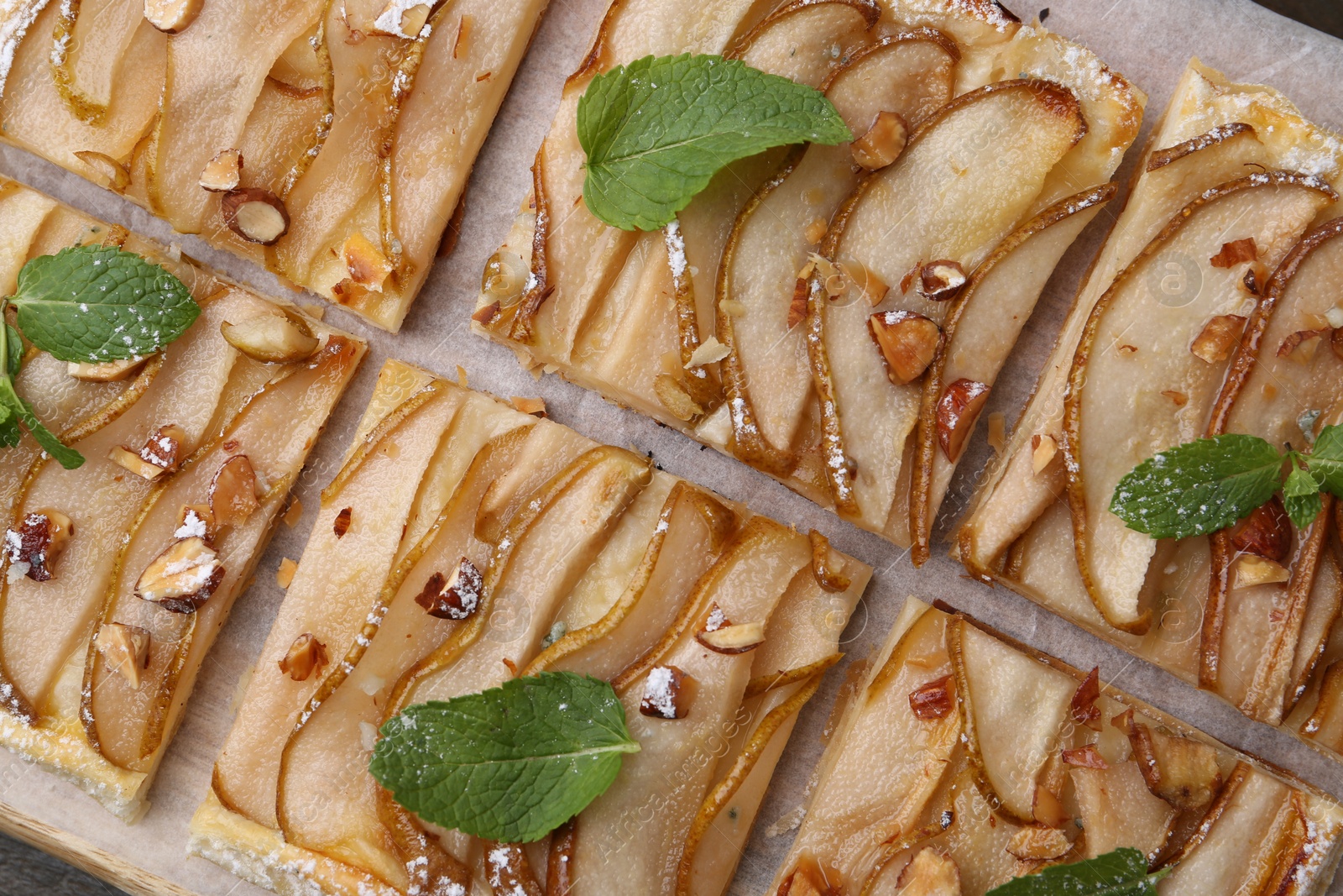 Photo of Tasty puff pastry pie with pears and mint on table, top view