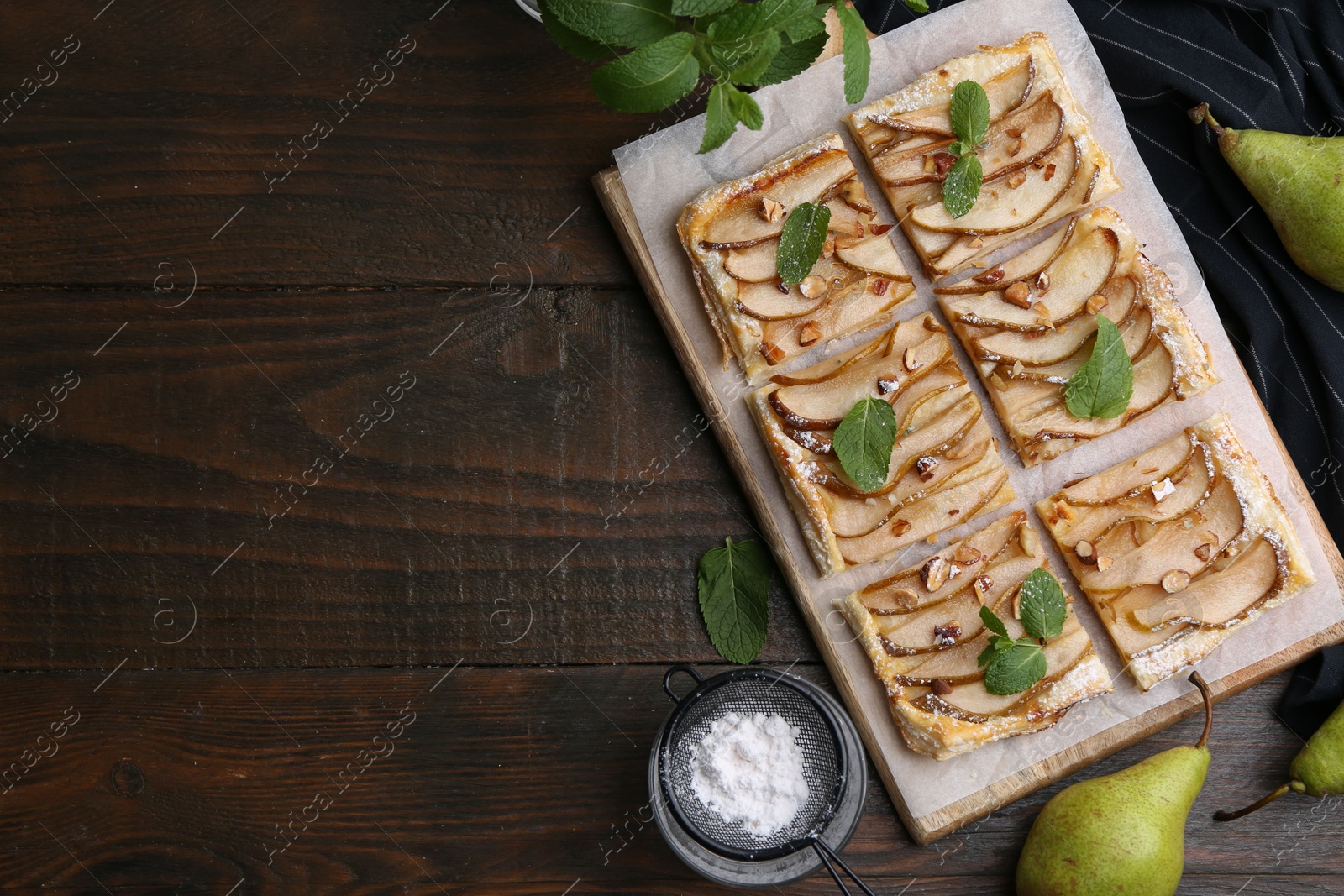 Photo of Tasty puff pastry pie with pears, mint and powdered sugar on wooden table, top view. Space for text