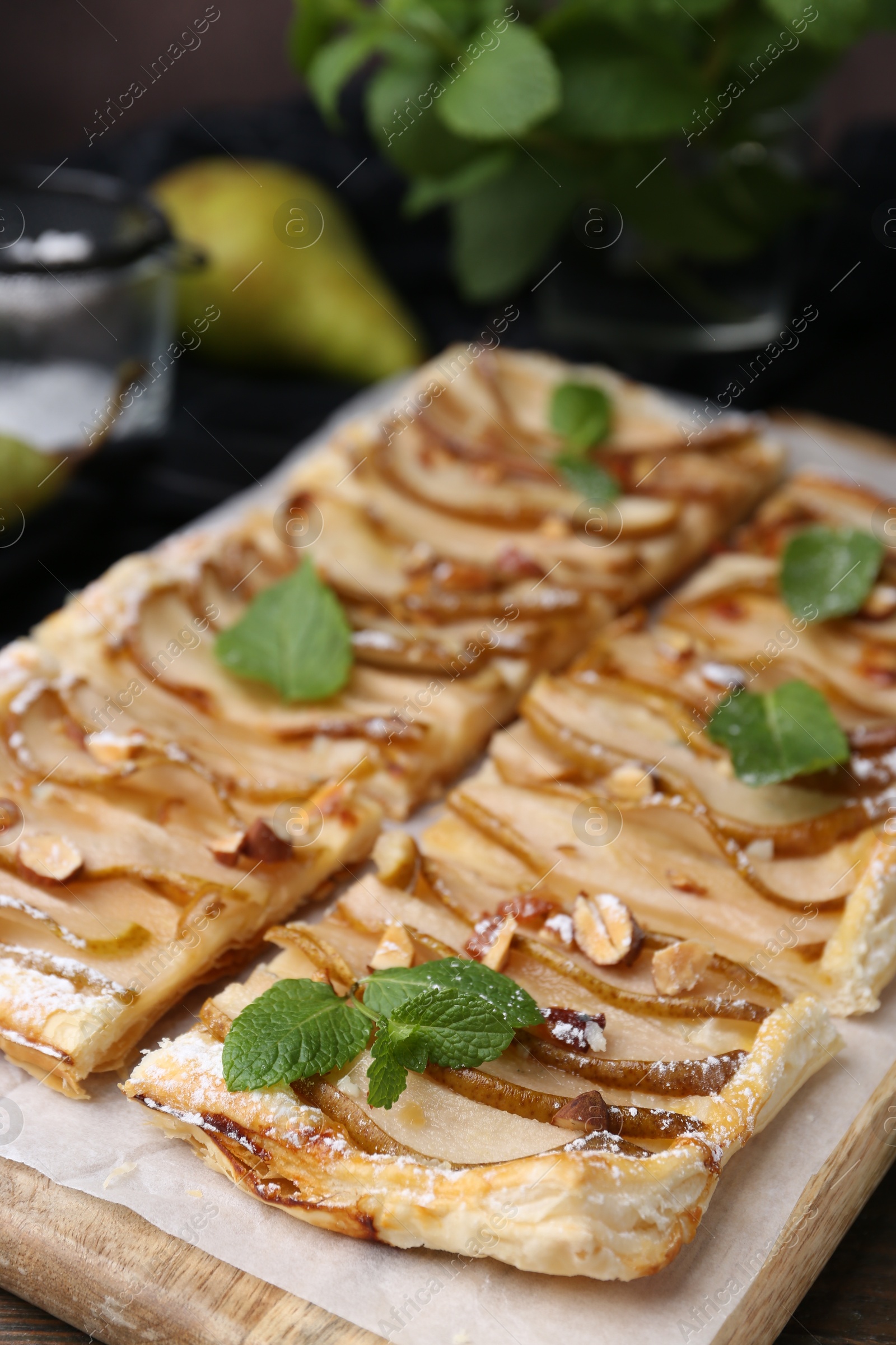 Photo of Tasty puff pastry pie with pears and mint on table, closeup