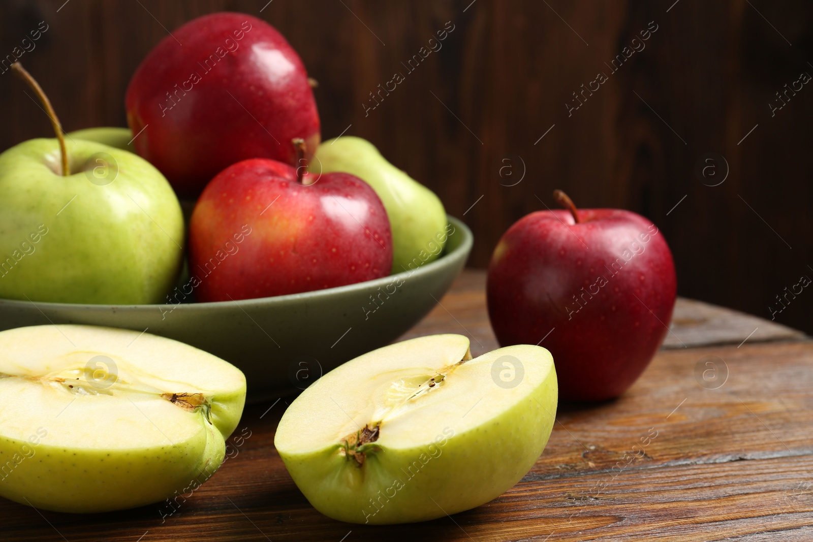 Photo of Fresh red and green apples on wooden table, closeup