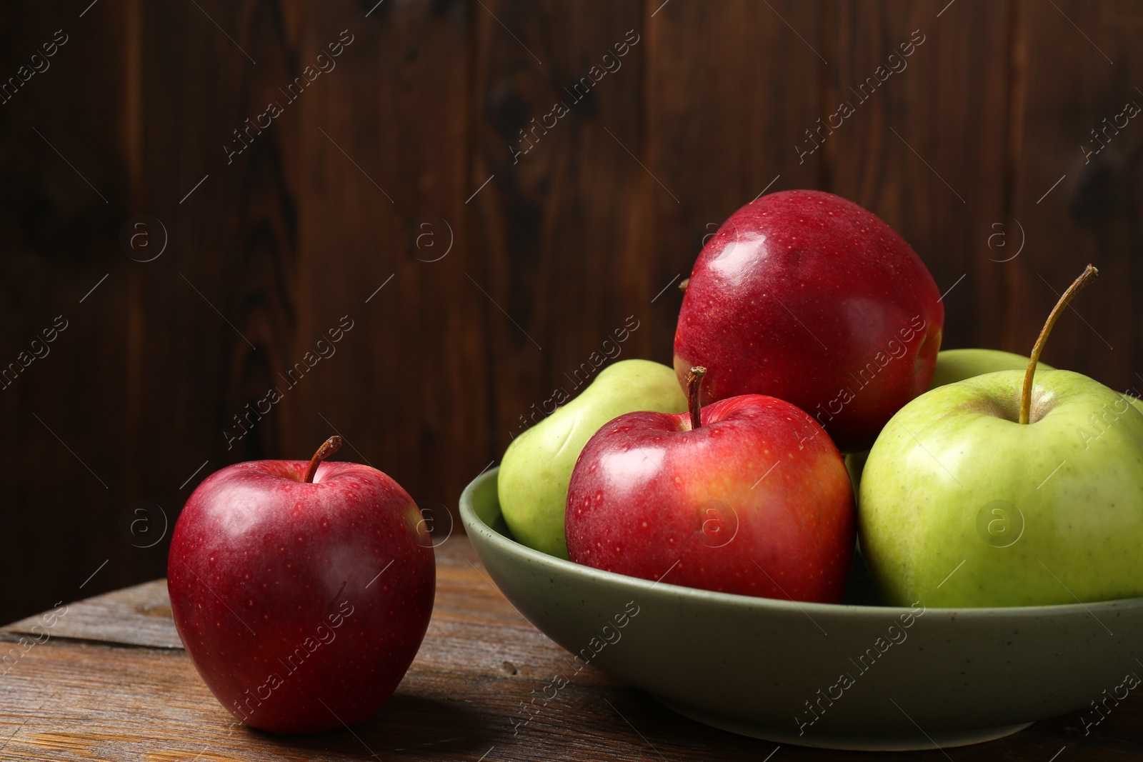 Photo of Fresh red and green apples on wooden table, closeup