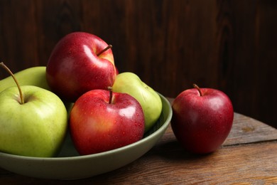 Photo of Fresh red and green apples on wooden table, closeup