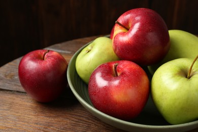 Photo of Fresh red and green apples on wooden table, closeup