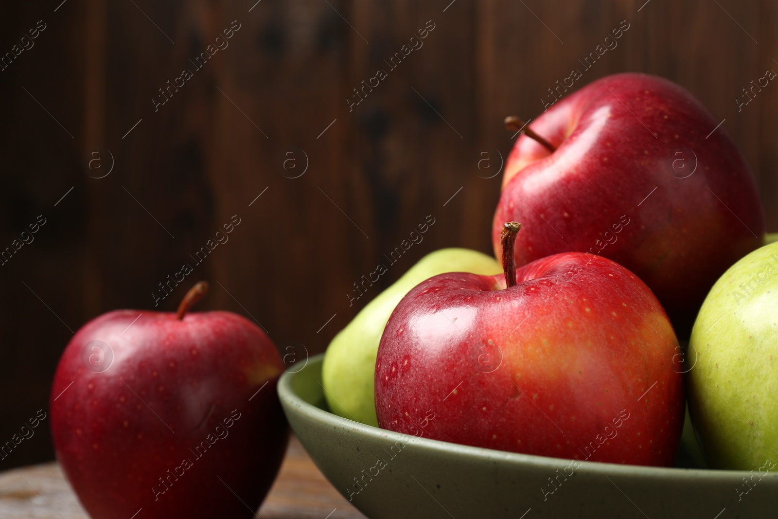 Photo of Fresh red and green apples on wooden table, closeup