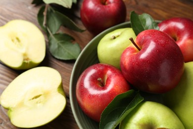 Photo of Fresh red and green apples on wooden table, closeup