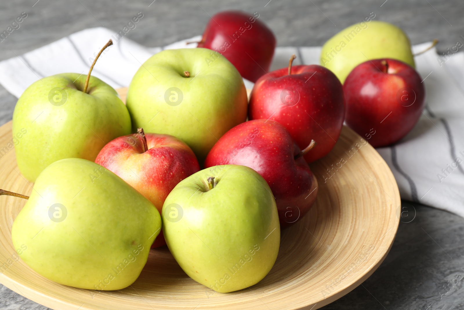 Photo of Fresh red and green apples on grey table, closeup