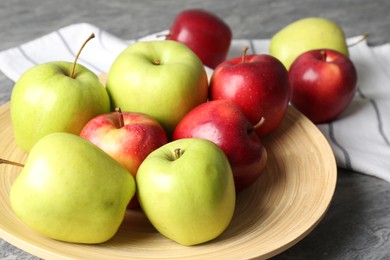 Photo of Fresh red and green apples on grey table, closeup