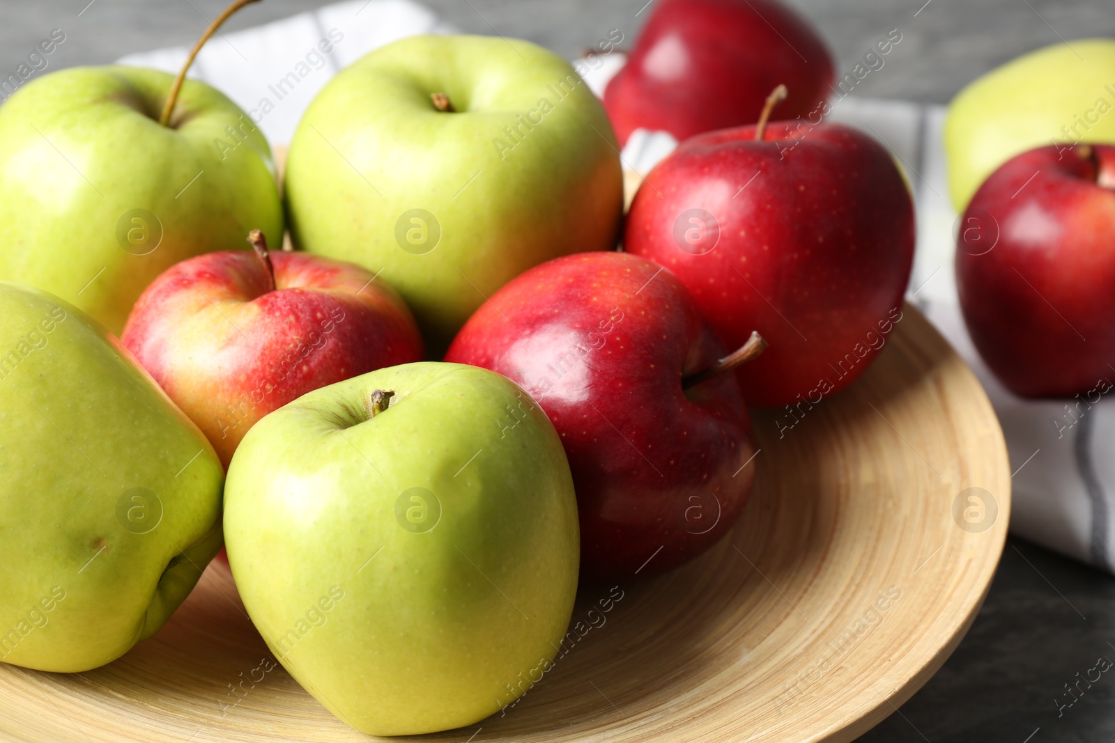 Photo of Fresh red and green apples on grey table, closeup