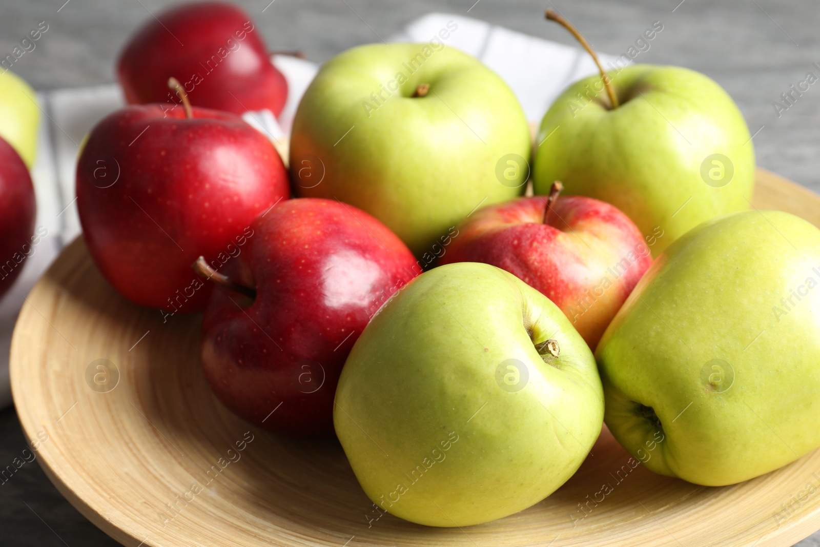 Photo of Fresh red and green apples on grey table, closeup