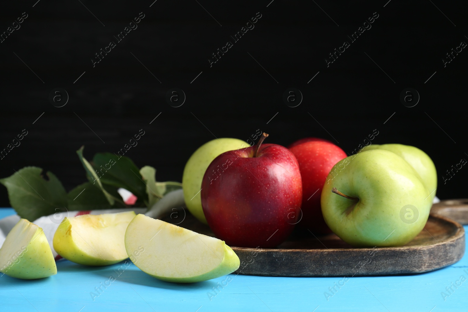 Photo of Fresh red and green apples on light blue wooden table