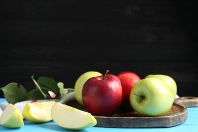 Photo of Fresh red and green apples on light blue wooden table