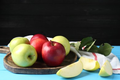 Photo of Fresh red and green apples on light blue wooden table