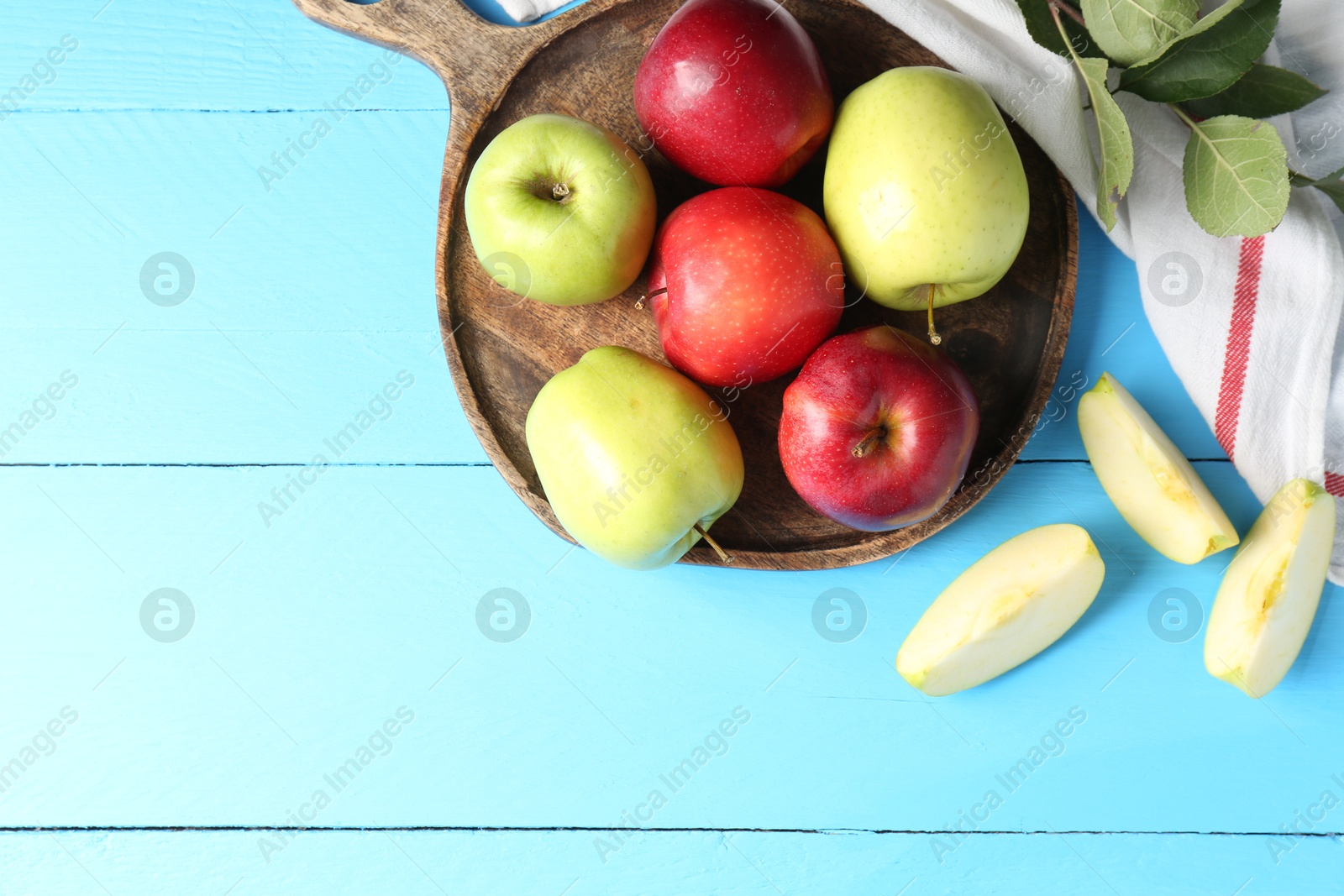 Photo of Fresh red and green apples on light blue wooden table, flat lay. Space for text