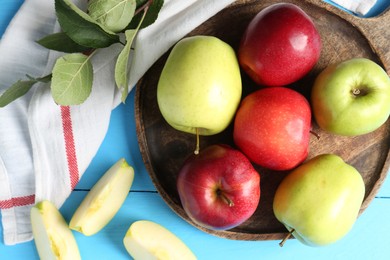 Photo of Fresh red and green apples on light blue wooden table, flat lay