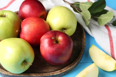 Photo of Fresh red and green apples on light blue wooden table, closeup