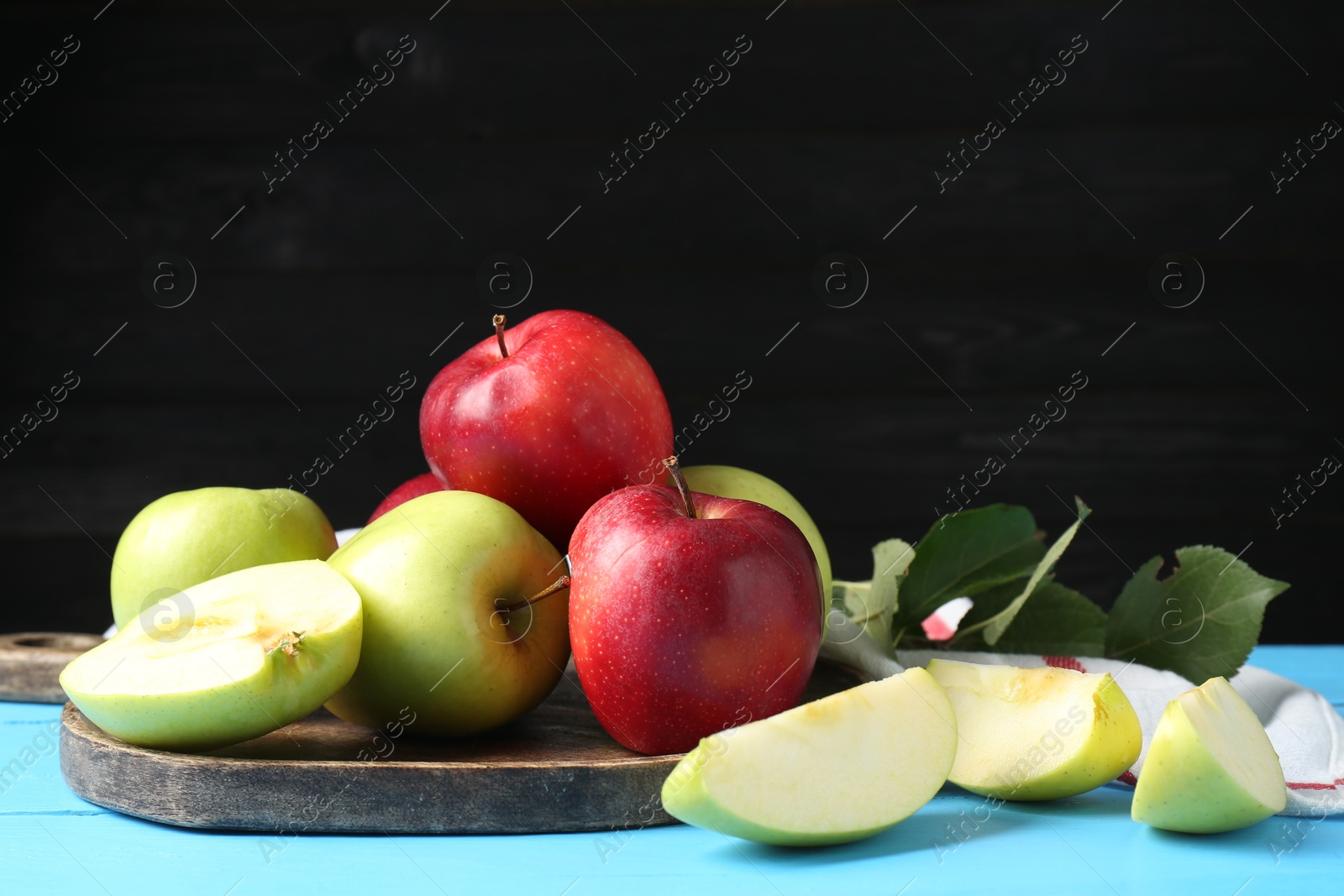 Photo of Fresh red and green apples on light blue wooden table