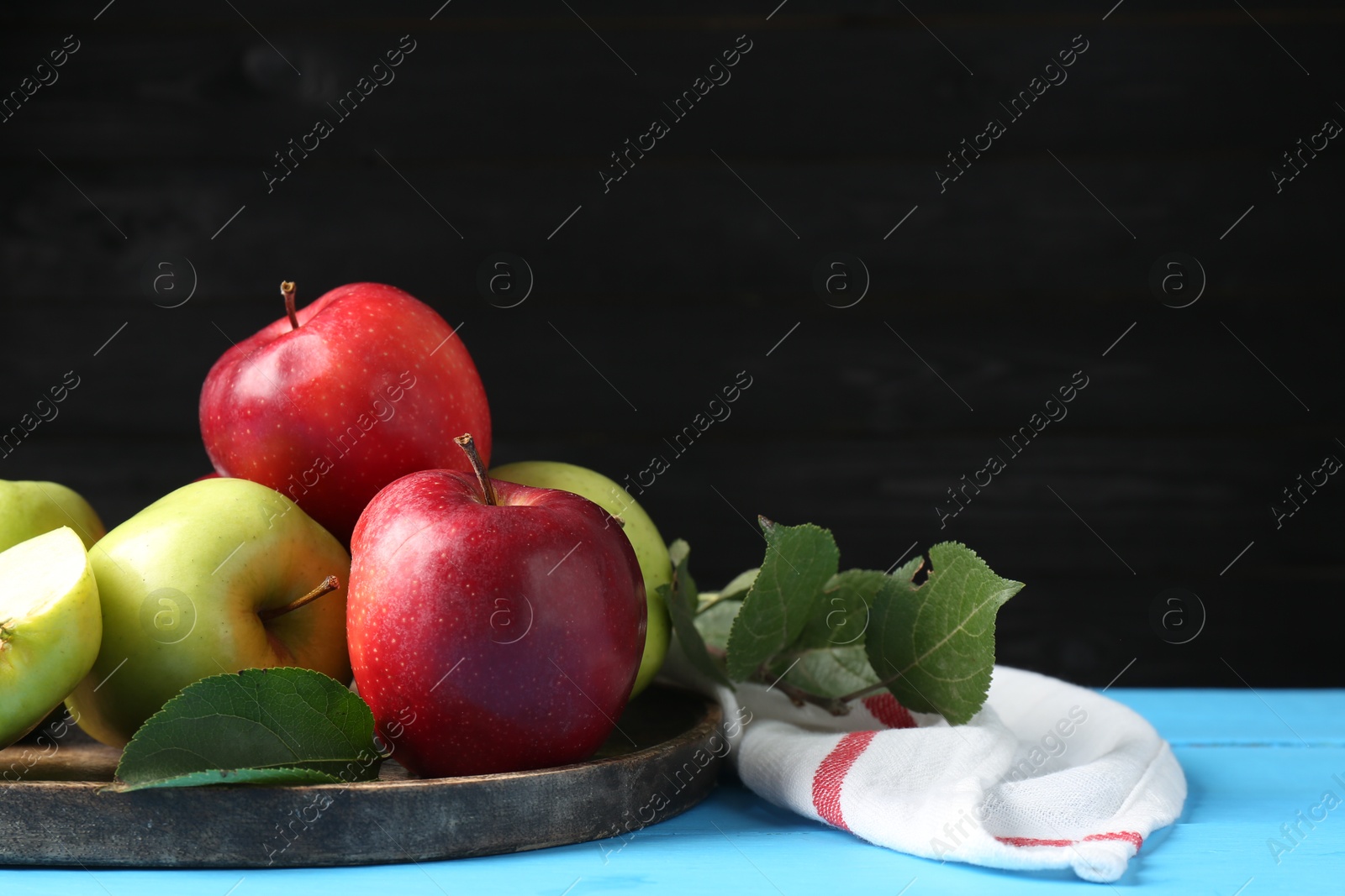 Photo of Fresh red and green apples on light blue wooden table