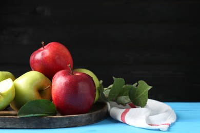 Photo of Fresh red and green apples on light blue wooden table