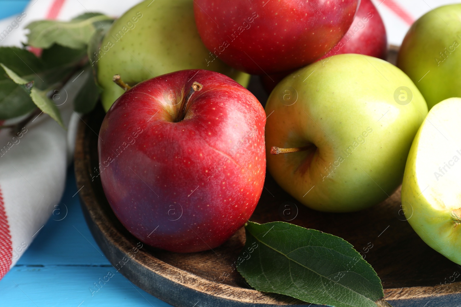 Photo of Fresh red and green apples on light blue wooden table, closeup