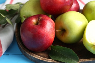 Photo of Fresh red and green apples on light blue wooden table, closeup