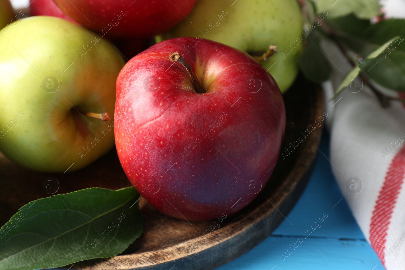 Photo of Fresh red and green apples on light blue wooden table, closeup