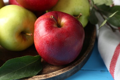 Photo of Fresh red and green apples on light blue wooden table, closeup