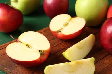 Photo of Fresh ripe apples on green wooden table, closeup