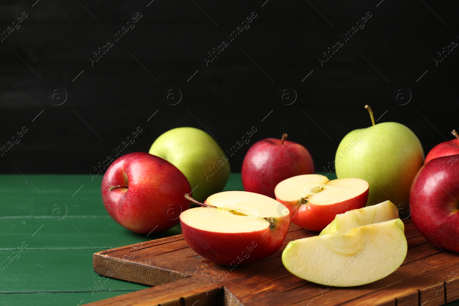 Photo of Fresh ripe apples on green wooden table