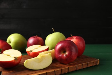 Photo of Fresh ripe apples on green wooden table