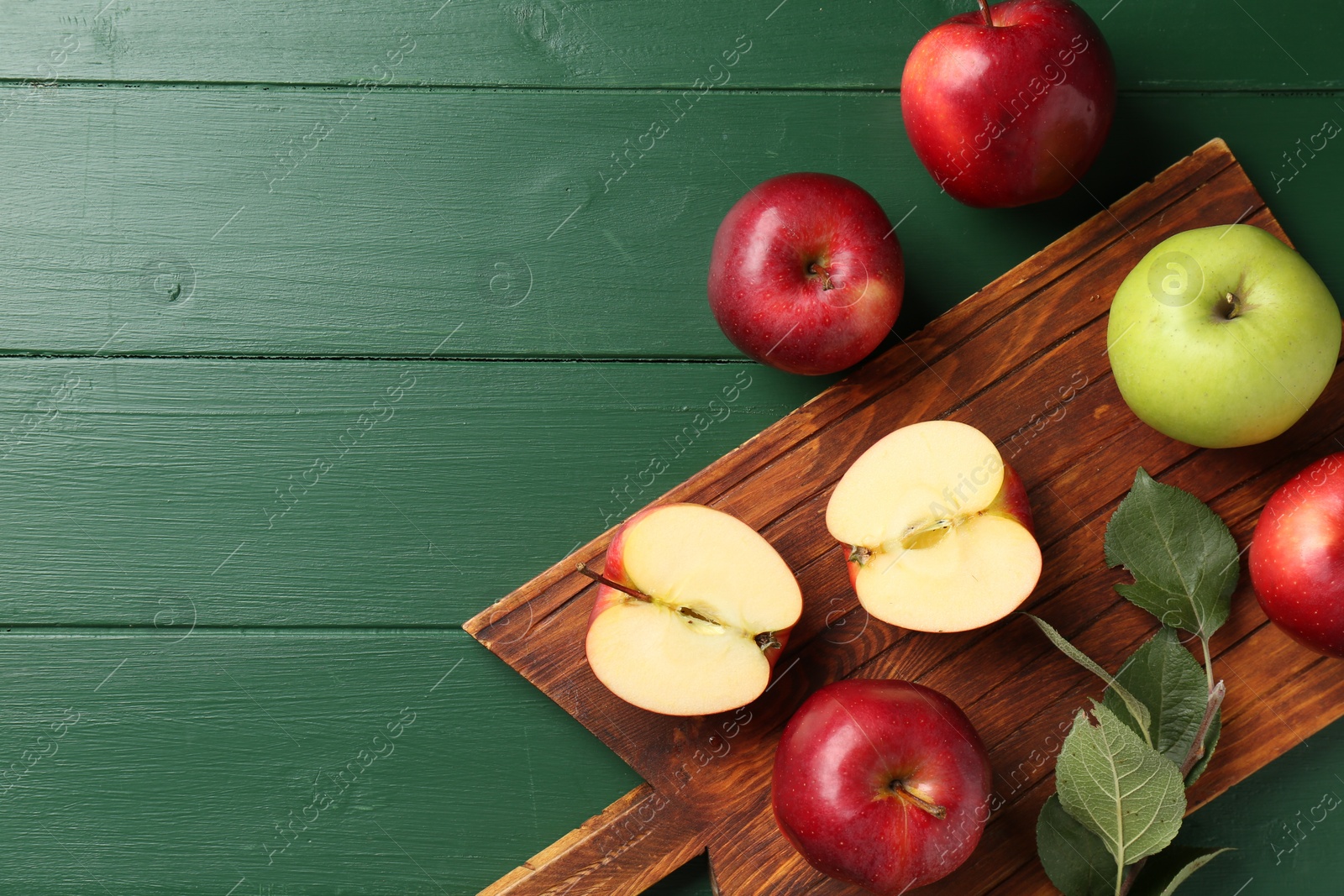 Photo of Fresh ripe apples on green wooden table, flat lay. Space for text