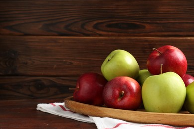 Photo of Fresh red and green apples on wooden table, space for text